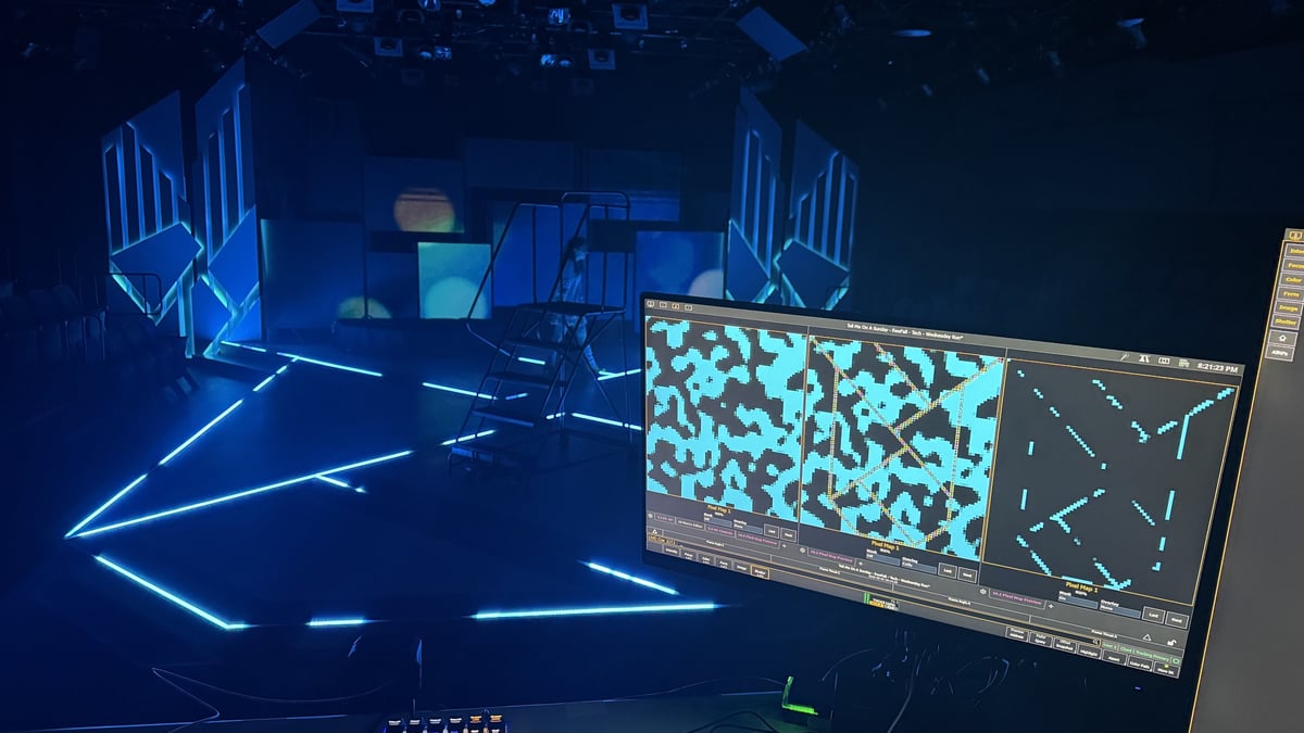 The blue neon set lit during tech, with the magic sheet on the monitor.