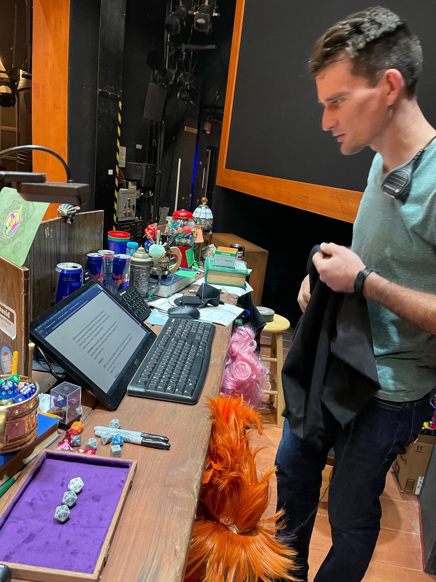 A team member at the tech table beside one of the show's dragon puppets.
