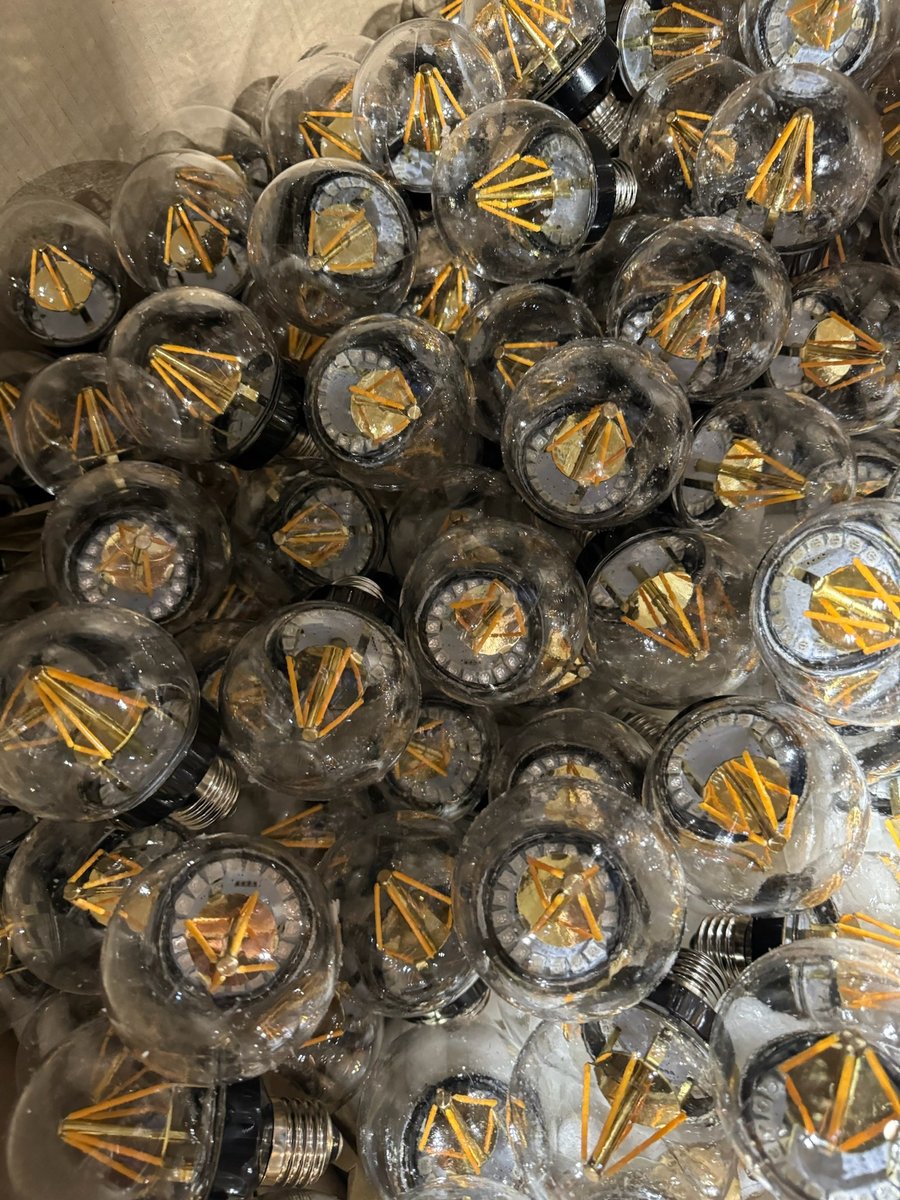 A bin of clear globe LED filament bulbs, the decorative practical lamps used throughout the tavern set.