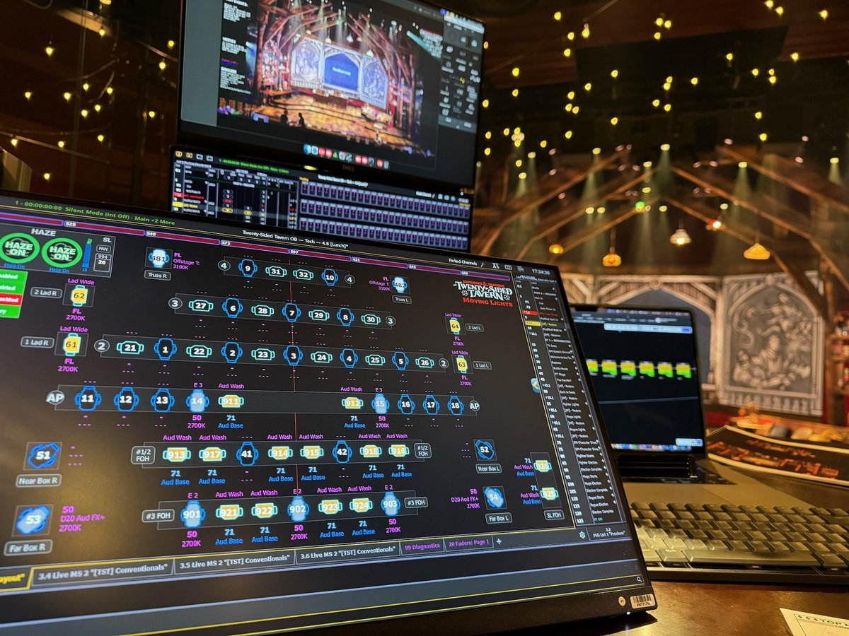 Close-up of the custom Eos magic sheet on the programming monitor, its channels tagged with twenty-sided die icons, the lit tavern set beyond.