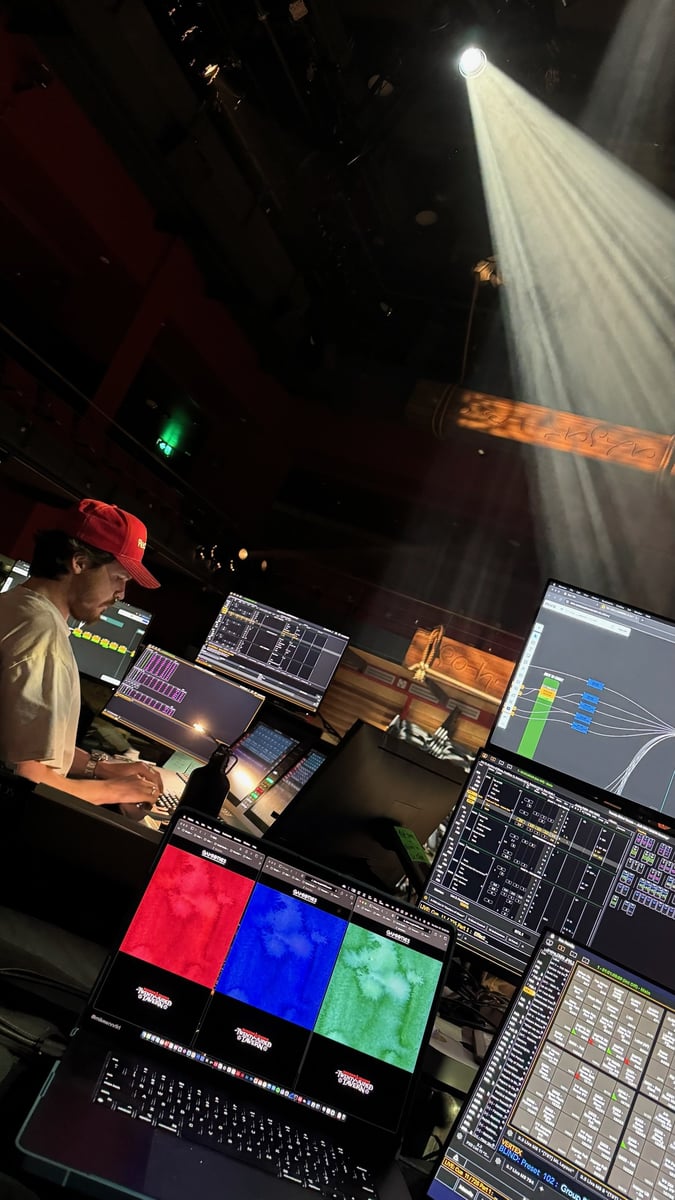 Programming from the tech table as a beam picks out the stage.