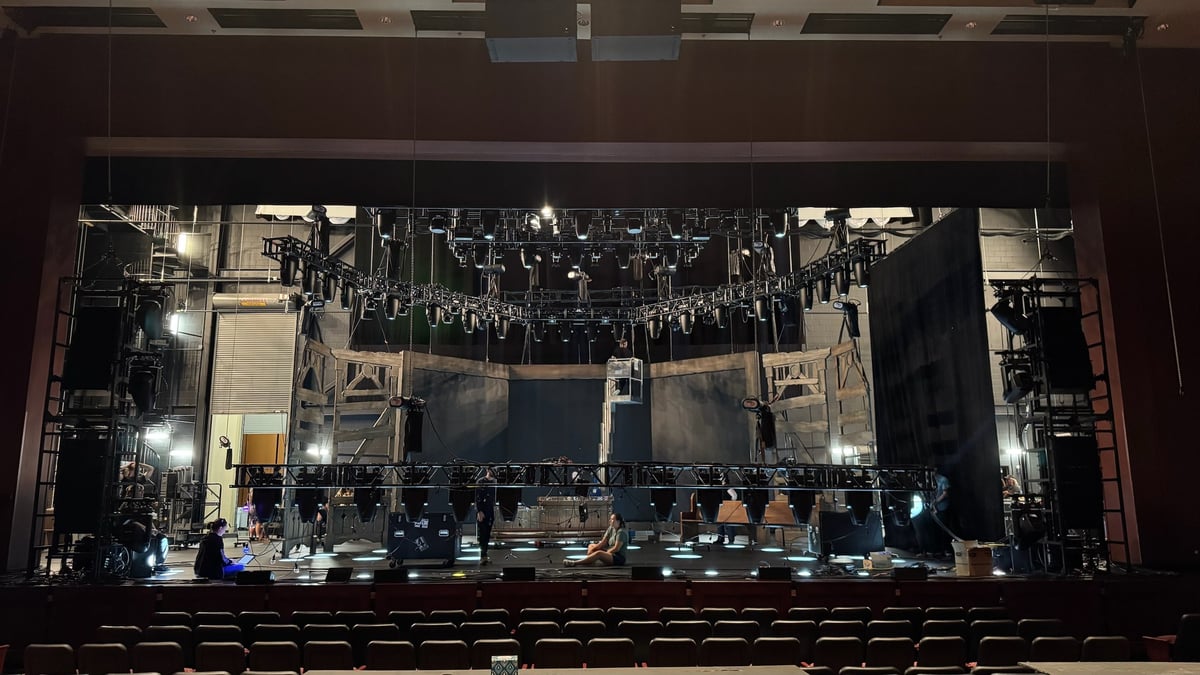 An empty proscenium house lit blue from the stage.