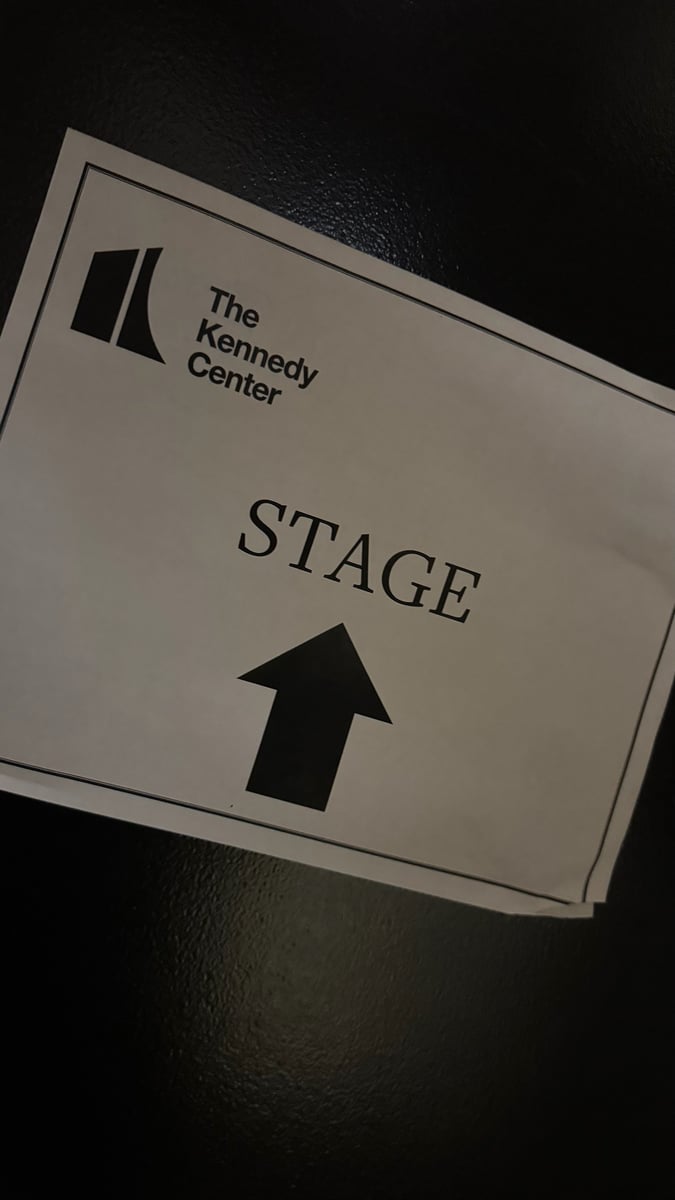 A backstage wayfinding sign pointing to the stage.