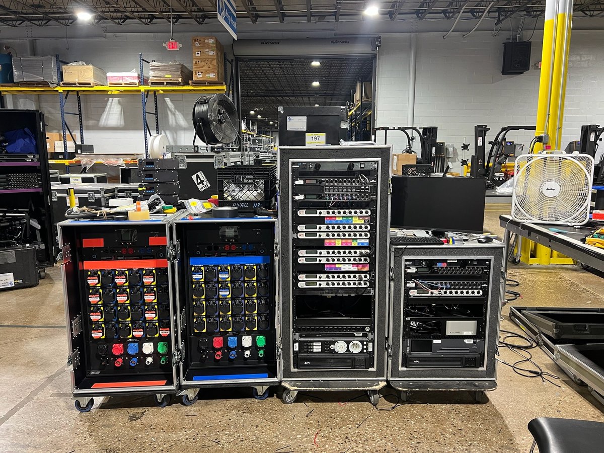 Road cases and gear staged backstage during load-in.