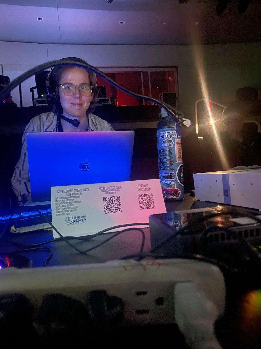 An operator in headset running the Eos console at the tech table.