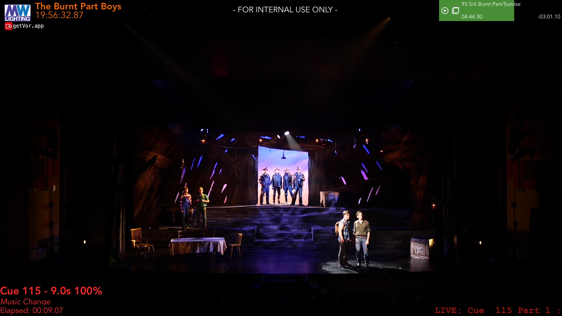 The same set in a night look, cool beams cutting through the timber slats, the company silhouetted upstage