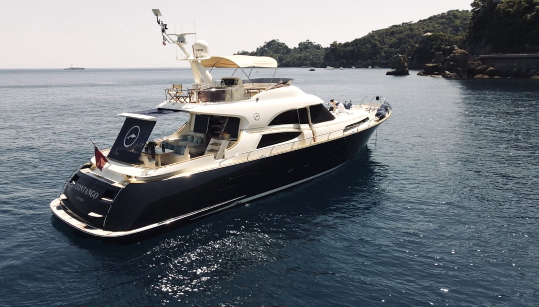 Mochi Craft Dolphin 74 M/Y Contango at anchor with the coastline behind