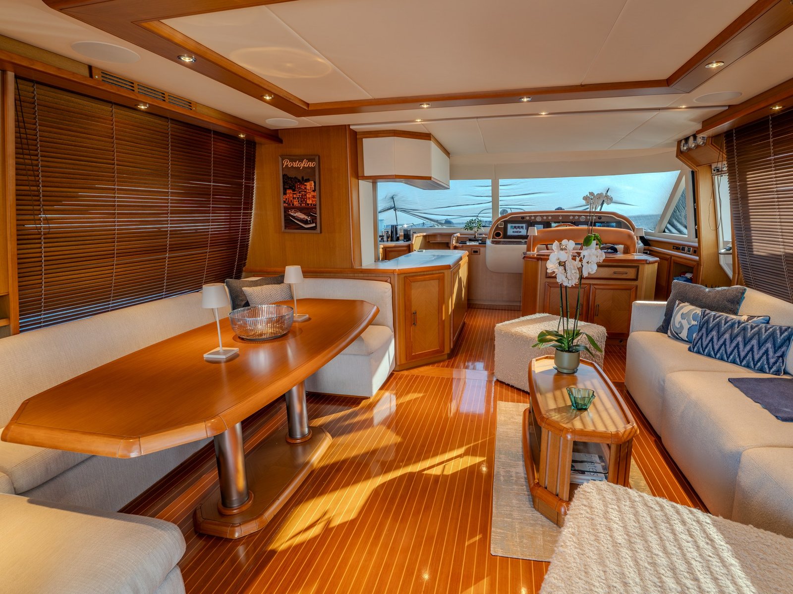 Der Salon über die volle Schiffsbreite der M/Y Contango mit Kirschholzausbau, formellem Esstisch und freier Sichtachse bis zur Konsole des unteren Fahrstands
