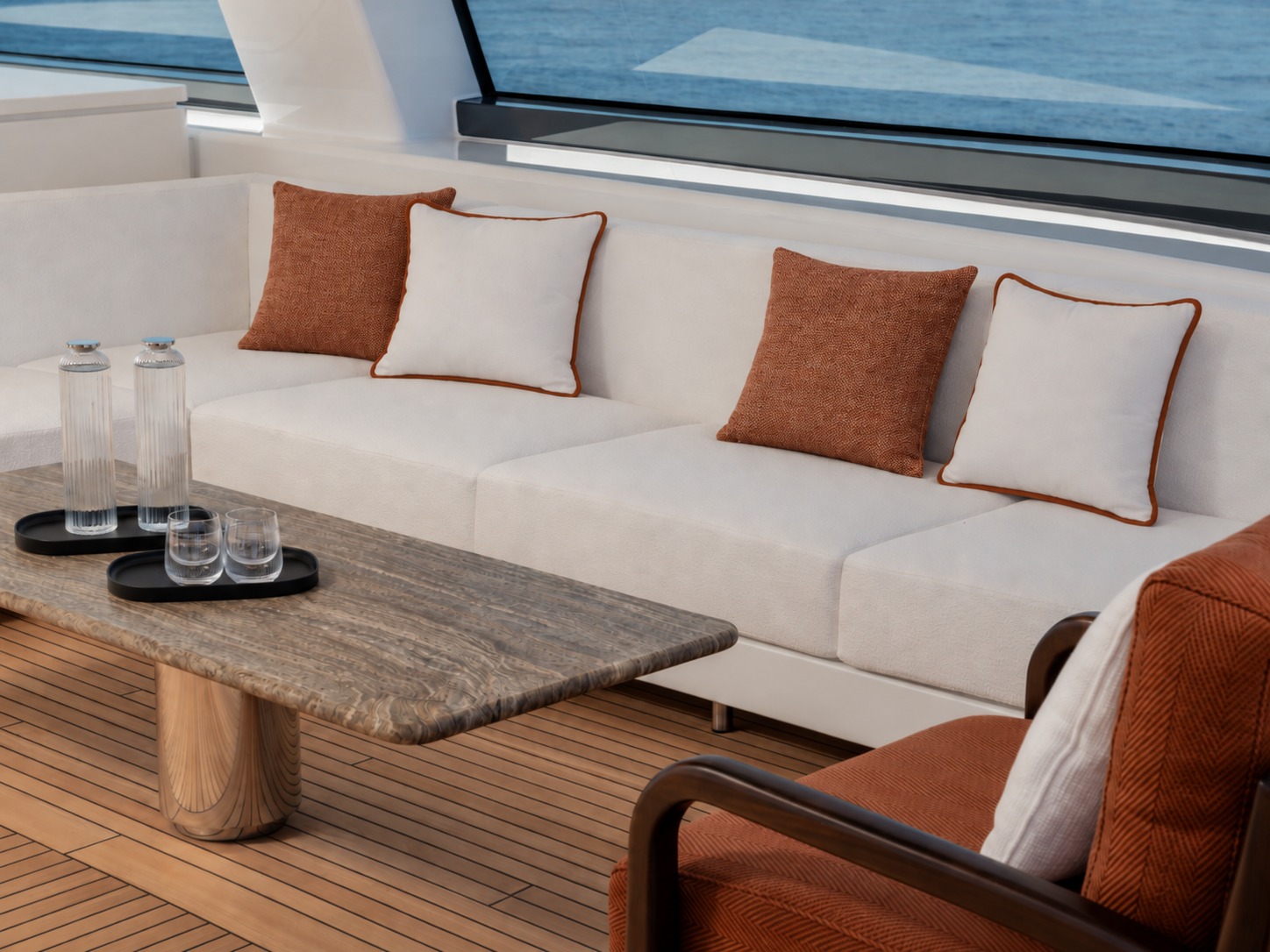 Lintea Mare cushions in terracotta and cream on a flybridge sofa aboard M/Y Inari, beside a marble coffee table