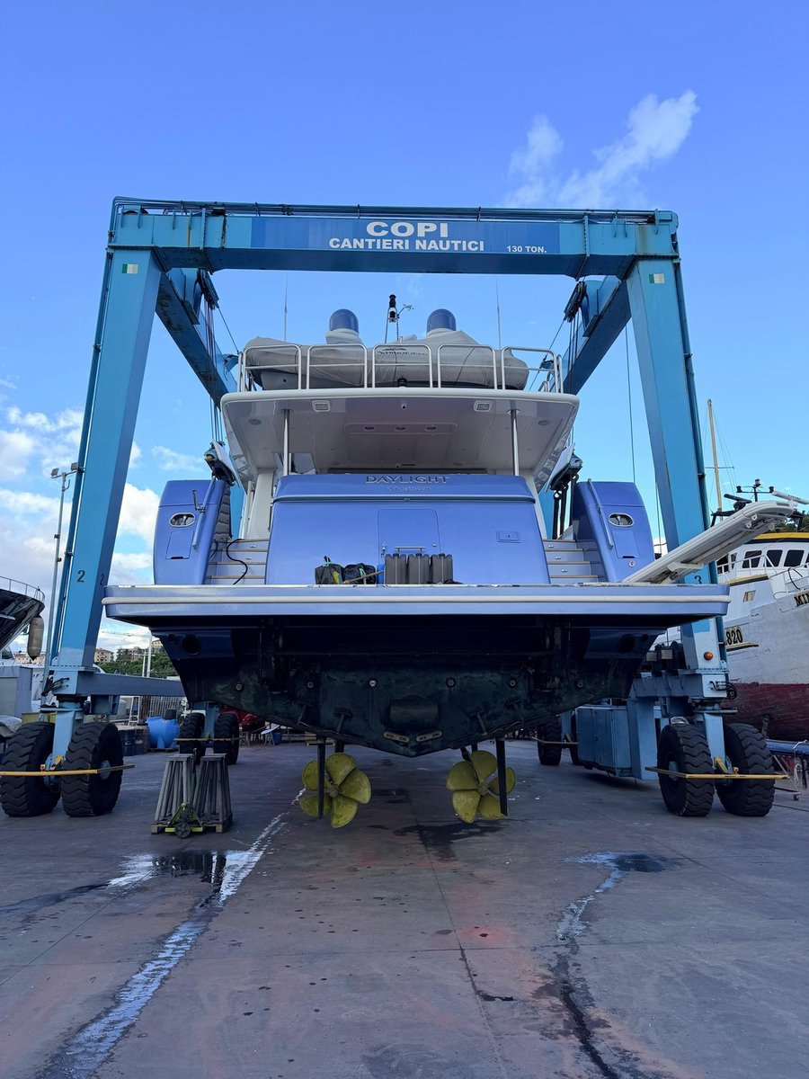 M/Y Daylight ashore on the hardstand at Copi Cantieri Nautici, still held in the 130-ton travel lift, seen from astern with her twin propellers in view