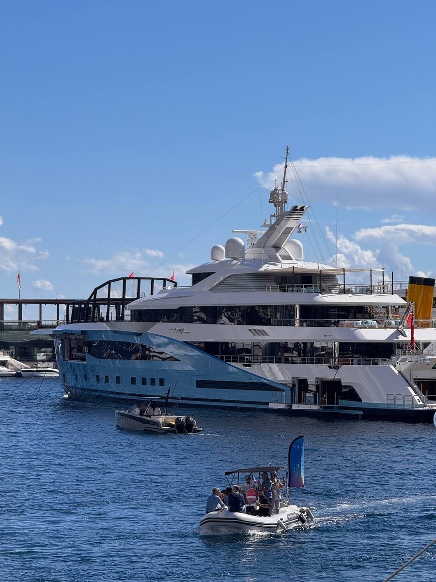 Tender navetta che porta i visitatori attraverso Port Hercule, davanti a un superyacht ormeggiato in banchina