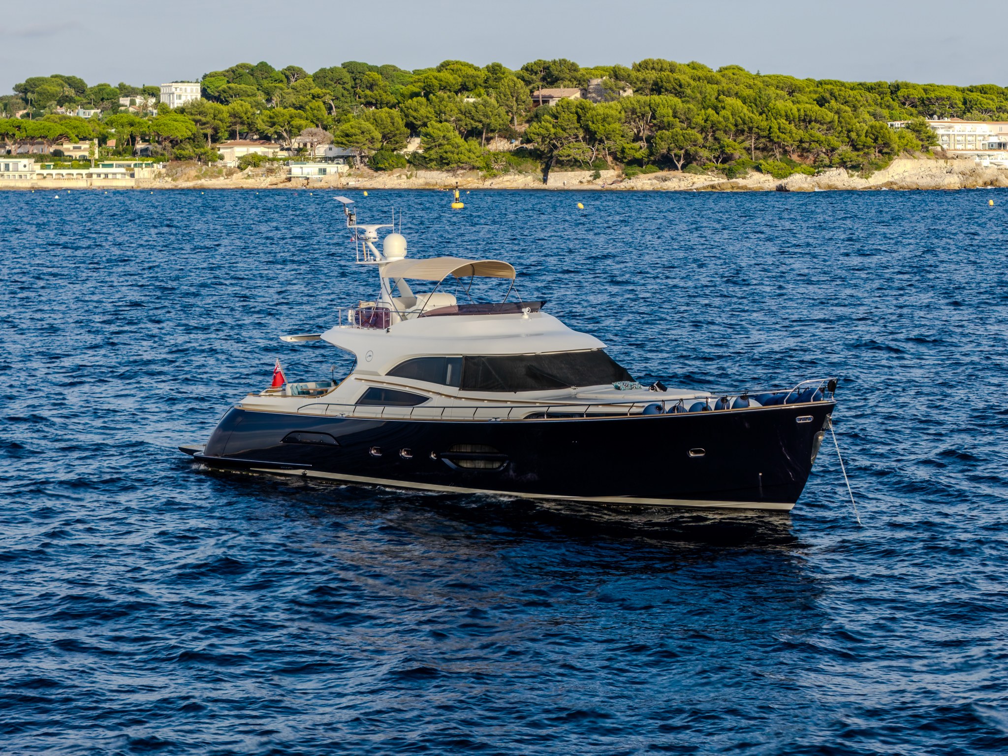 M/Y Contango, 2006 model Mochi Craft Dolphin 74, çam kaplı bir Akdeniz burnu açığında demirli