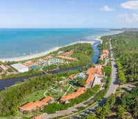 Vista aérea de município do Espírito Santo, mostrando áreas urbanas, vegetação e curso d’água.