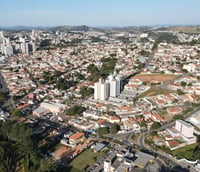 Vista aérea do centro de Itatiba (SP), com prédios baixos e áreas verdes em dia claro.