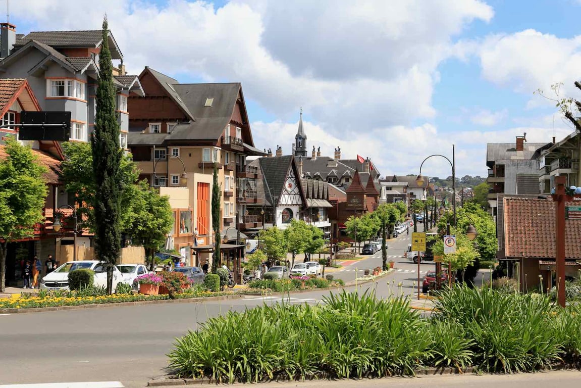 Centro urbano na Serra Gaúcha, com ruas arborizadas e prédios baixos, em imagem horizontal de dia