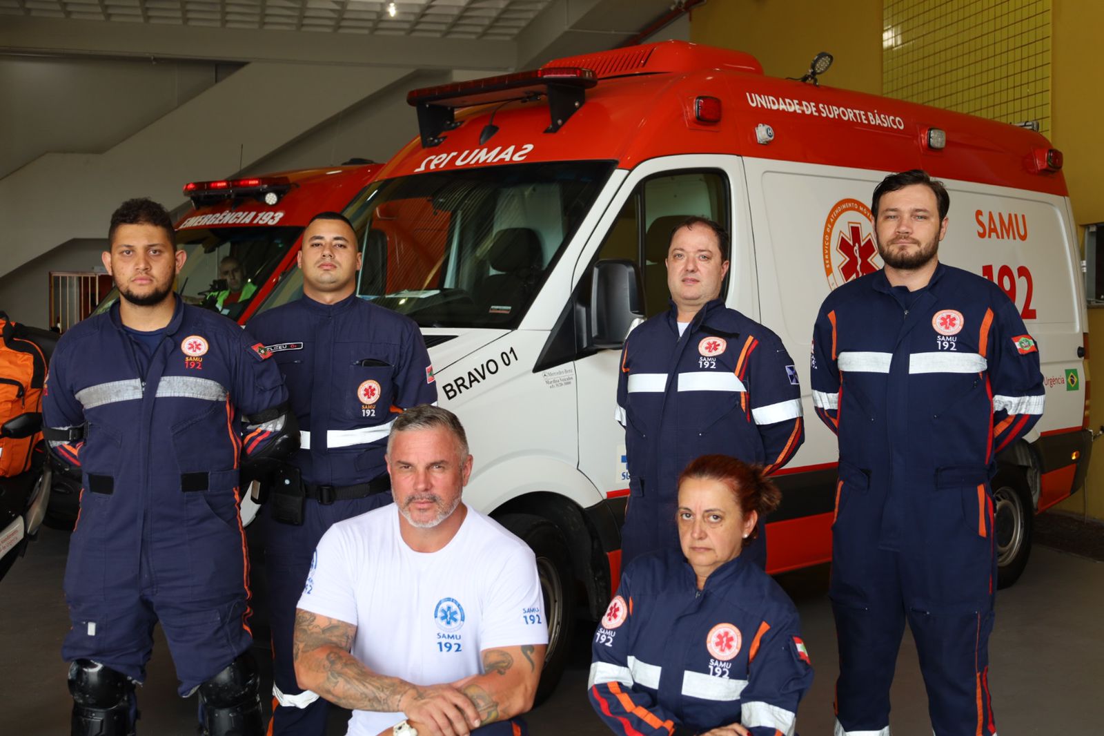 Equipe do SAMU em frente a ambulâncias