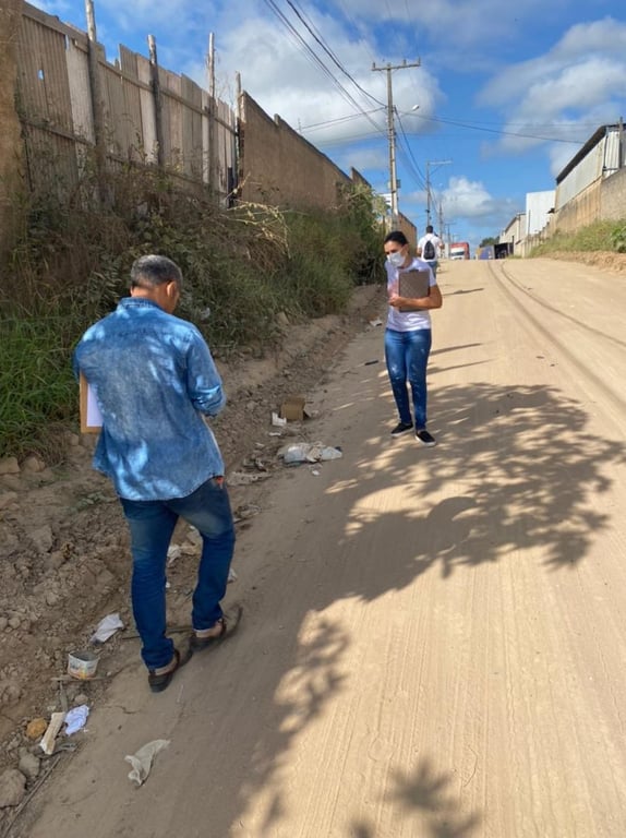 Agentes de saúde em atividade de campo, registrando informações em área urbana