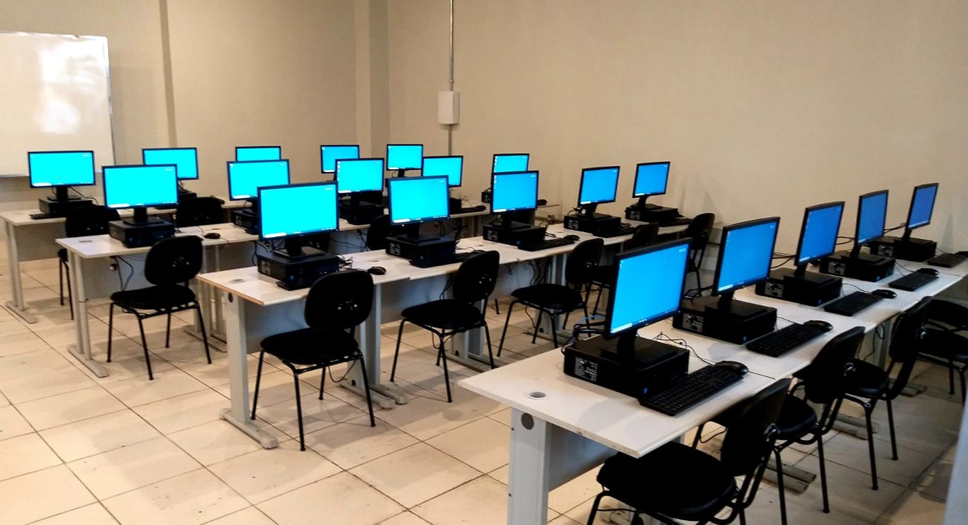 Laboratório de informática em ambiente acadêmico, com computadores alinhados