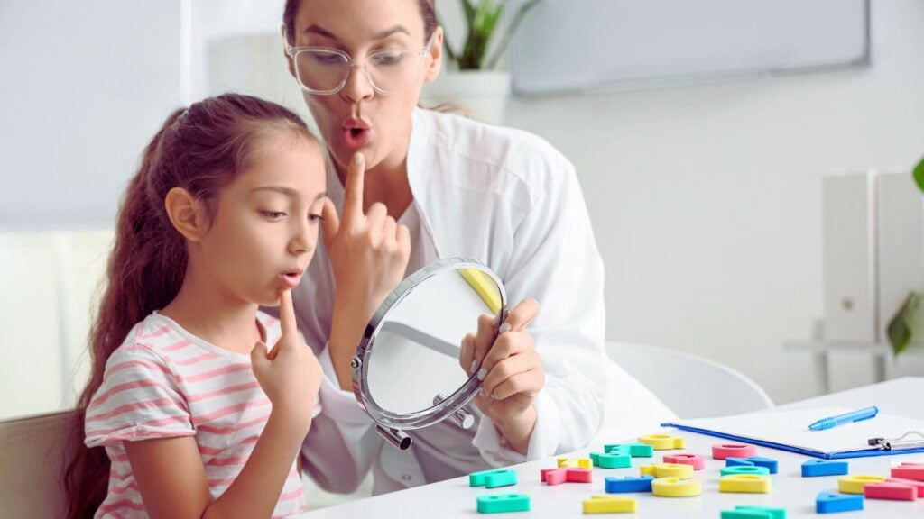 Atendimento fonoaudiológico infantil em consultório, com exercícios de articulação diante do espelho