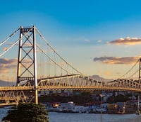 Vista aérea de Florianópolis ao entardecer, com ponte e centro da cidade
