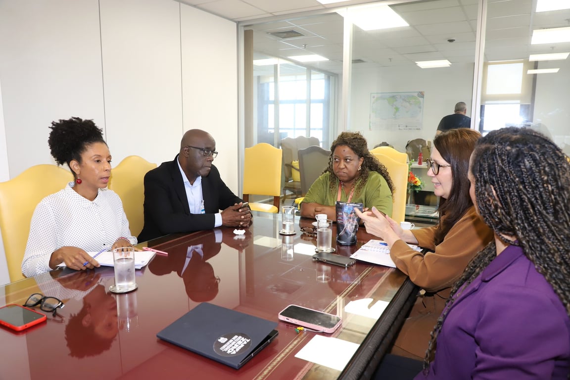 Profissionais de assistência social em reunião de trabalho, discutindo fluxos e atendimentos em equipe