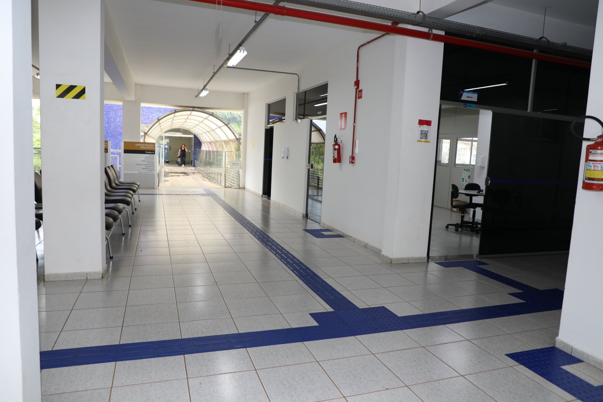 Corredor acadêmico na UNIFAL-MG, com estudantes ao fundo