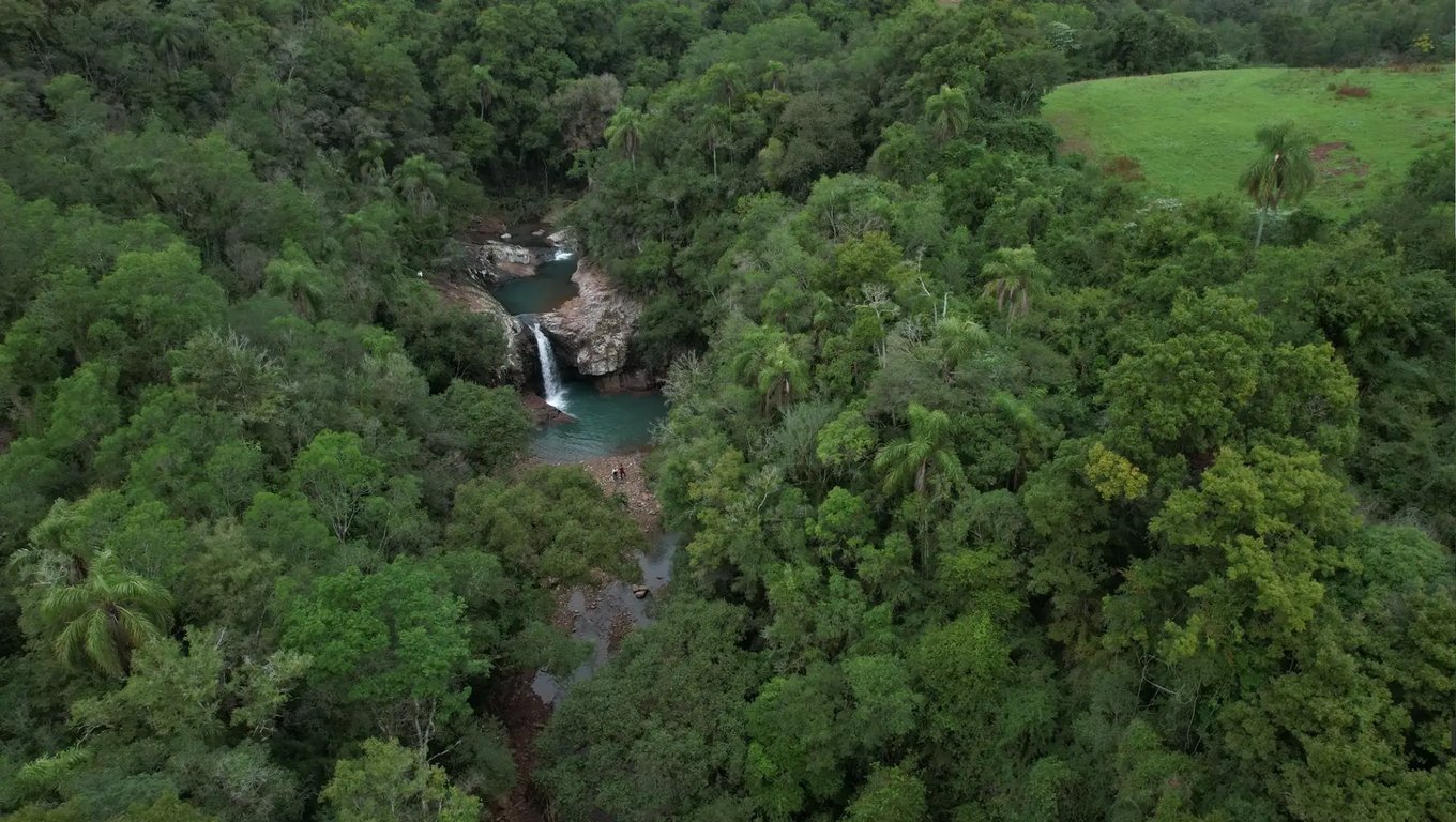 Paisagem da Serra do Sudeste, com vegetação densa e queda d’água, típica do interior gaúcho