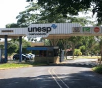 Entrada do campus da UNESP em Bauru com o logo da universidade visível na portaria.