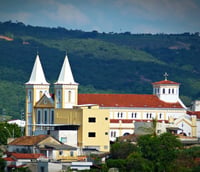 Vista urbana de Arcos MG, com igreja e colinas ao fundo