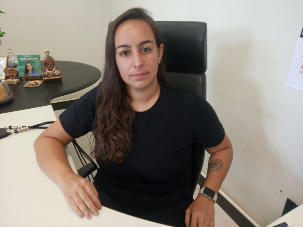 Servidora municipal em trabalho administrativo, com documentos e carimbo