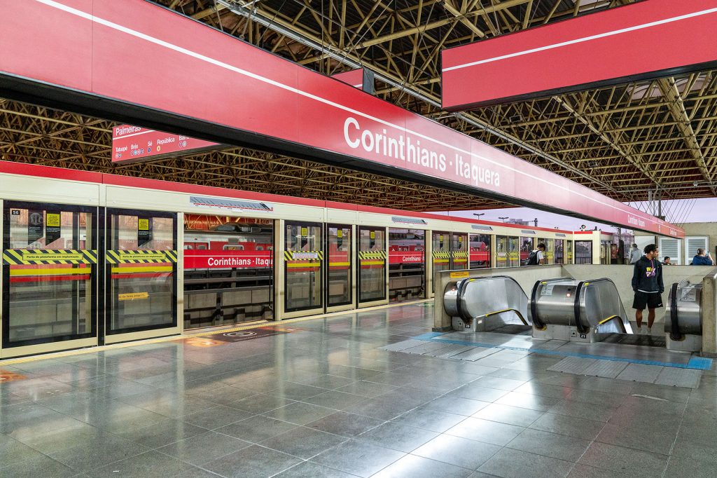 Estação de metrô em Itaquera, com circulação intensa de pessoas e trem ao fundo