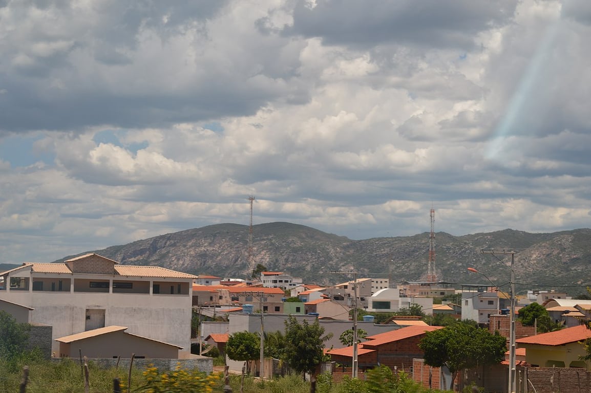 Vista aérea de uma pequena cidade no sertão semiárido brasileiro, com casas coloridas e paisagem de caatinga