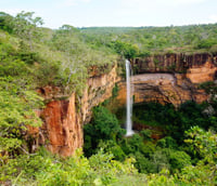 Paisagem natural no interior de Mato Grosso, com cachoeira e vegetação sob luz suave ao entardecer