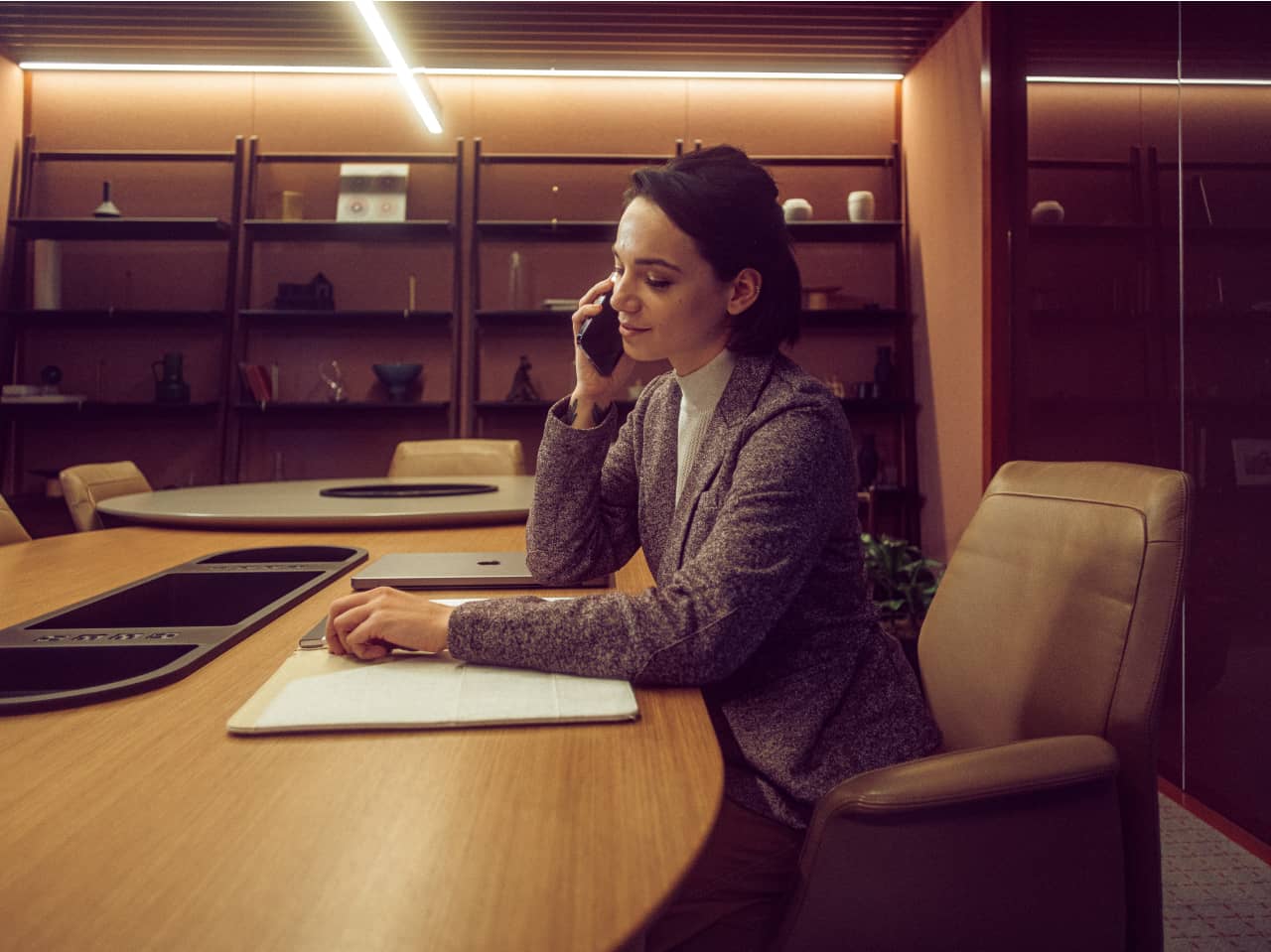 Ambiente corporativo com atendimento telefônico e múltiplas telas, remetendo à rotina de centrais de coordenação