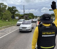 Agente do Detran-PA realiza fiscalização em rodovia paraense com viaturas ao fundo