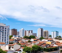 Vista aérea de Bauru SP ao entardecer, destacando o centro urbano e áreas verdes.