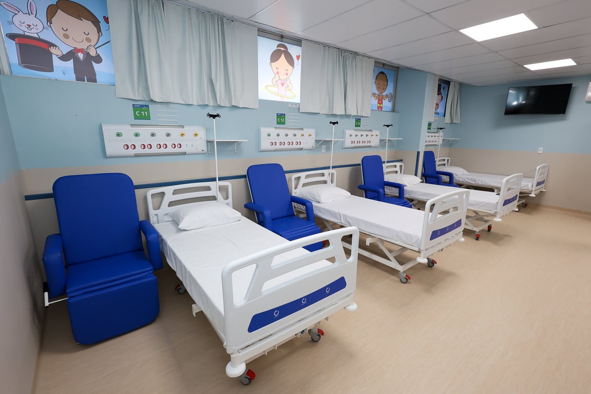 Ambiente hospitalar organizado, com leitos e poltronas em sala de atendimento