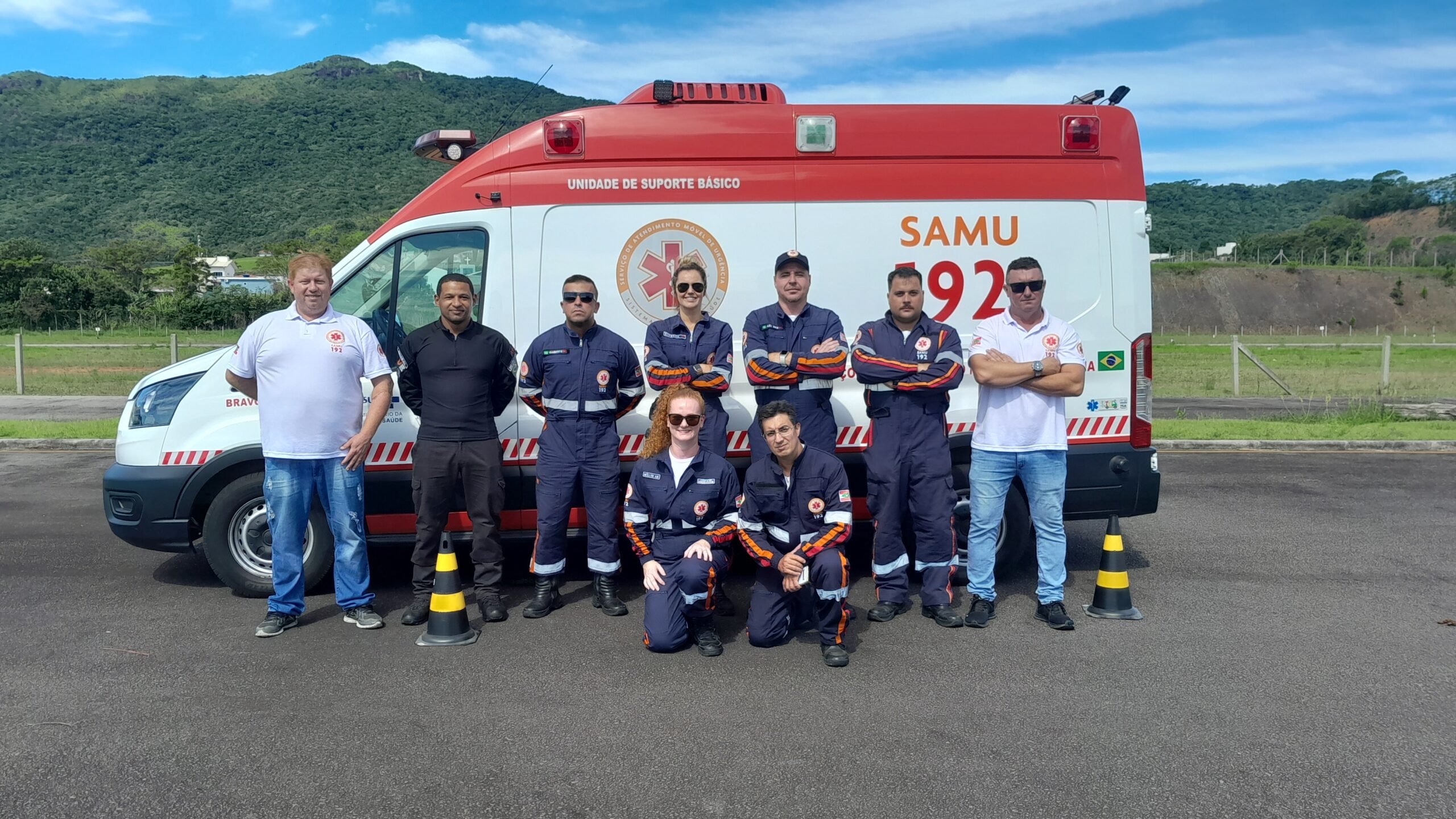 Equipe do SAMU posicionada ao lado de ambulância