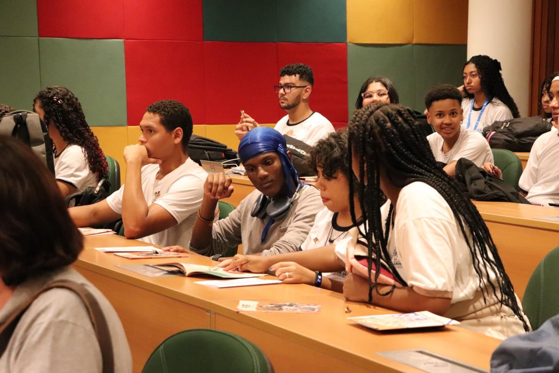 Jovens em ambiente de aprendizagem, em sala com mesas de madeira