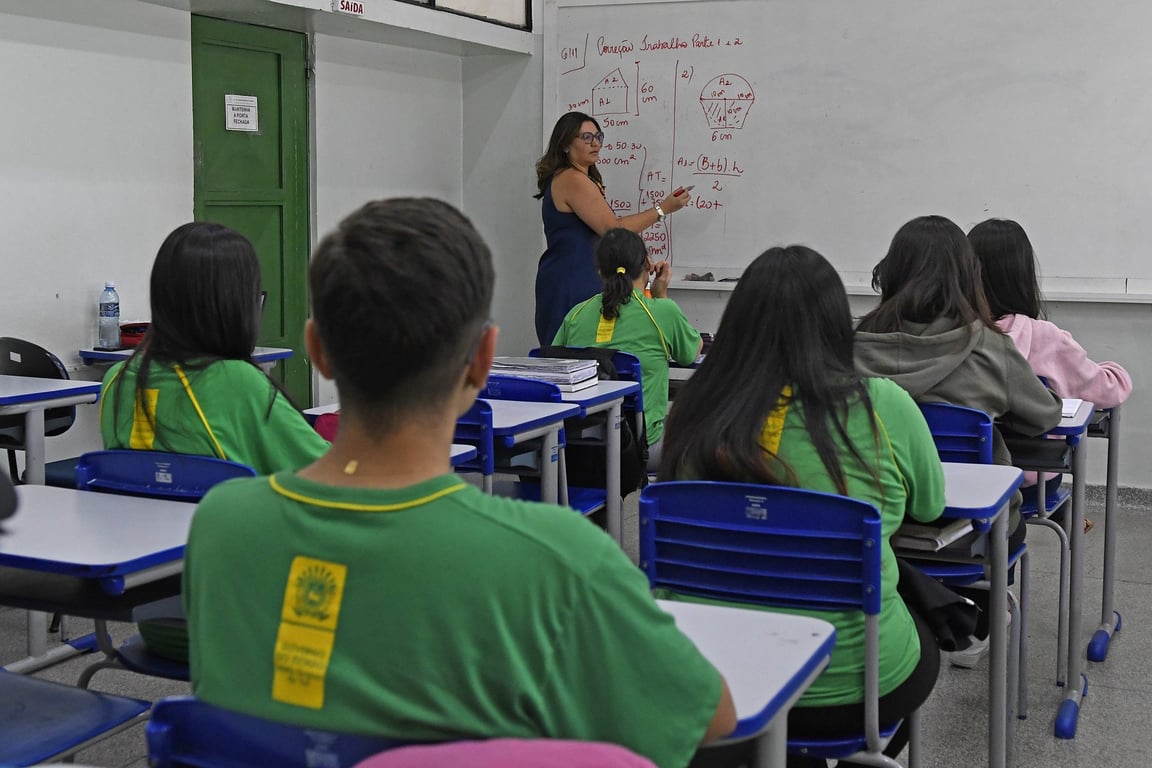 Ambiente de sala de aula com professora e alunos em escola pública