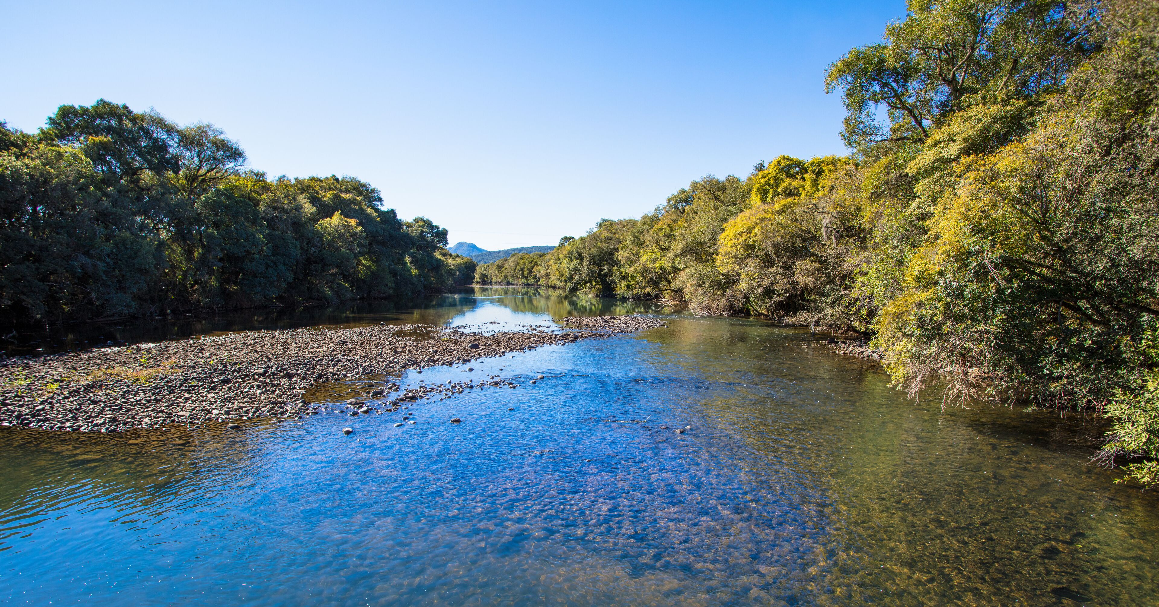Panorâmica de paisagem na região de Rio Verde GO, com curso d’água, vegetação e céu aberto