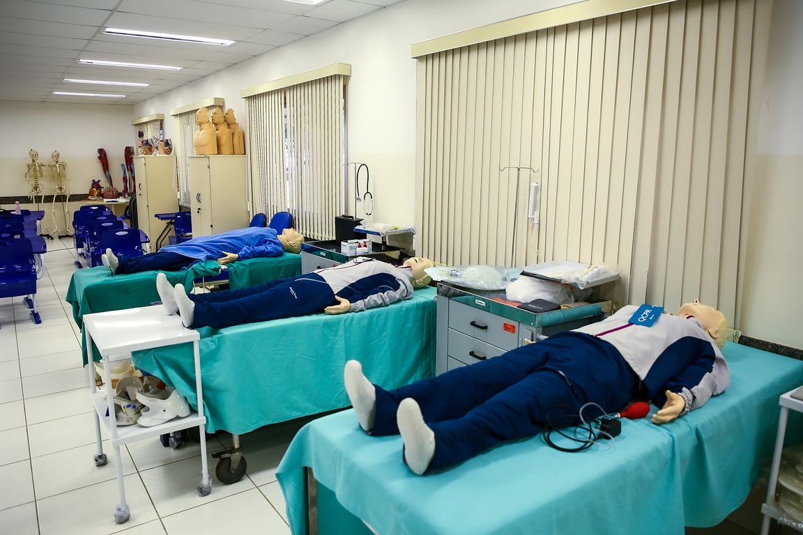 Laboratório de simulação de enfermagem, com manequins e estudantes em atividade