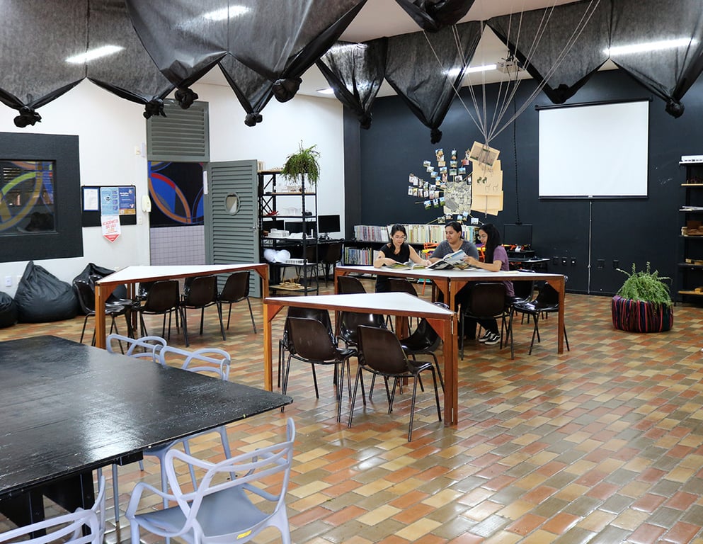 Sala de aula universitária moderna, com mesas e estudantes, iluminação natural