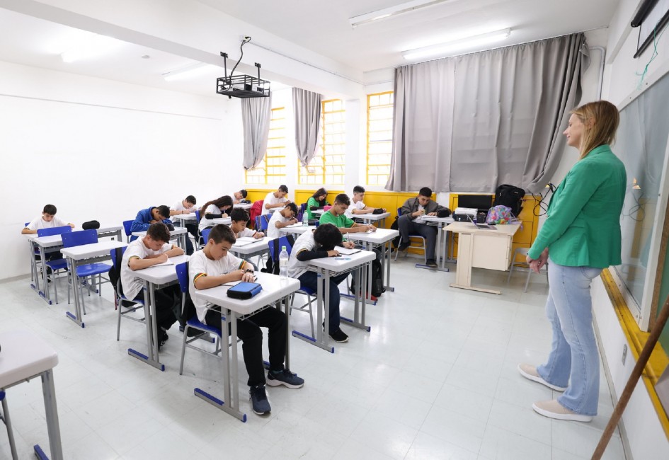 Sala de aula de escola pública no Rio Grande do Sul; alunos em atividade sob supervisão da professora