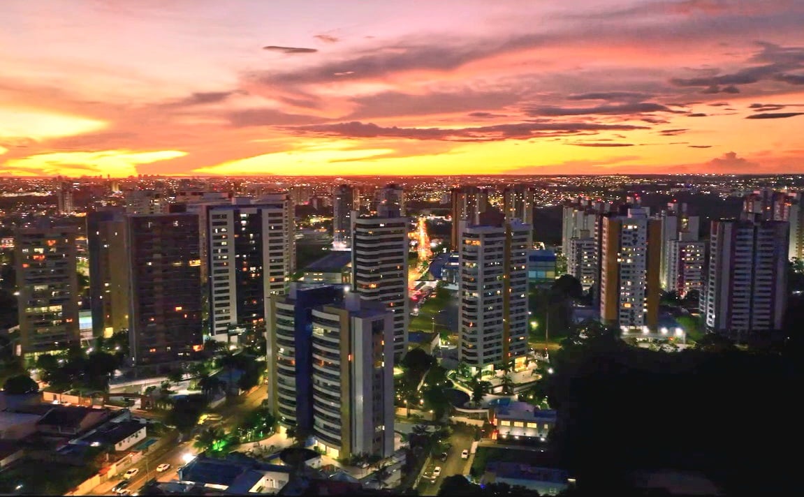 Horizonte de Manaus AM ao entardecer, com prédios iluminados e céu colorido