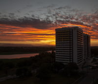 Paisagem urbana de Sobral CE ao entardecer, com prédios e a Serra da Meruoca ao fundo.