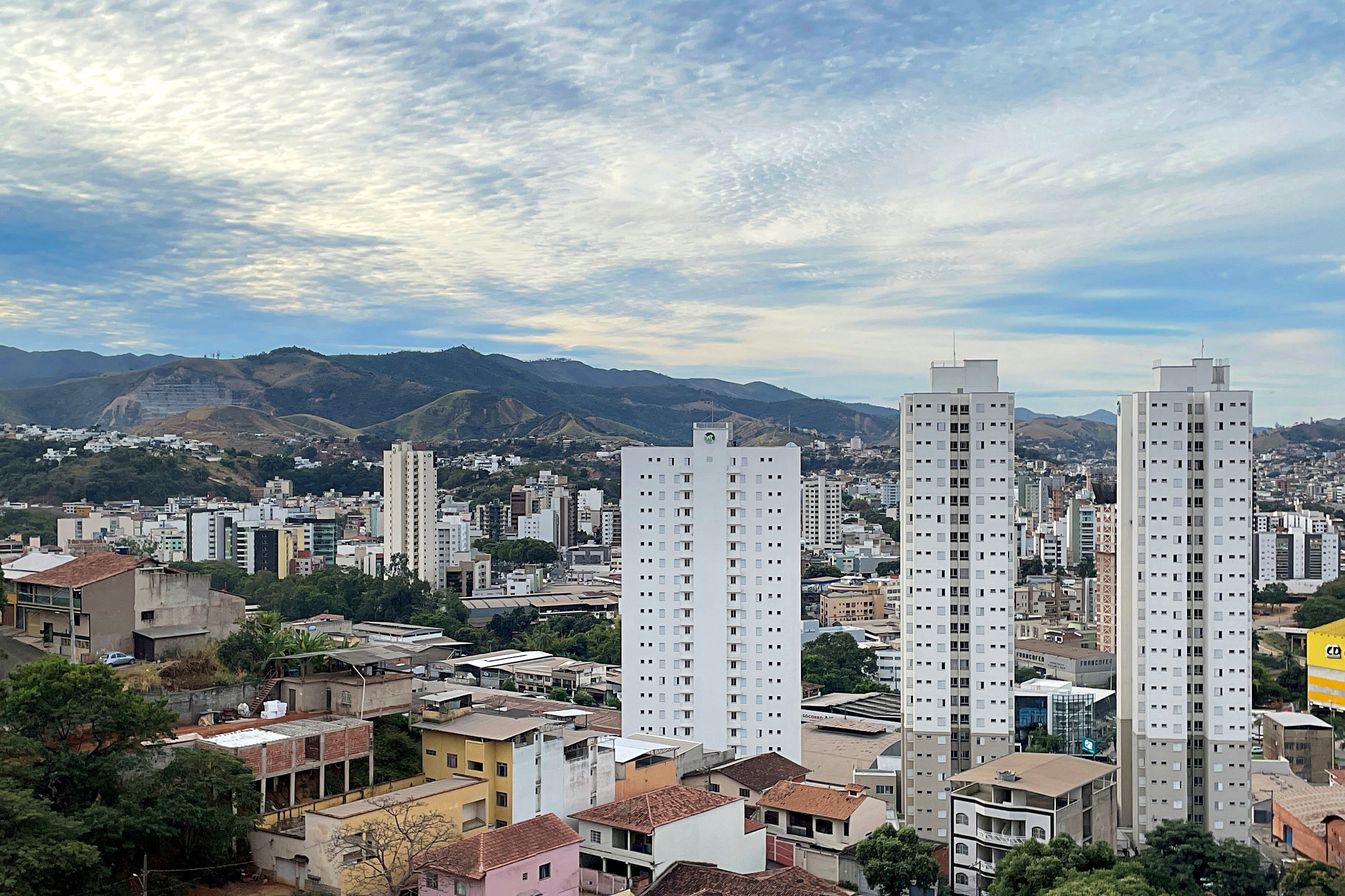 Vista panorâmica de Ipatinga, com área urbana, vegetação e serras ao fundo