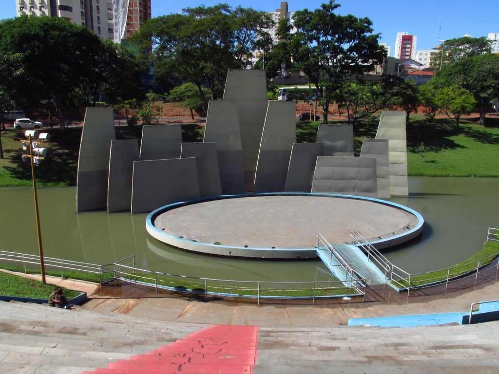 Parque urbano em Bauru SP ao entardecer, com lago e estrutura arquitetônica