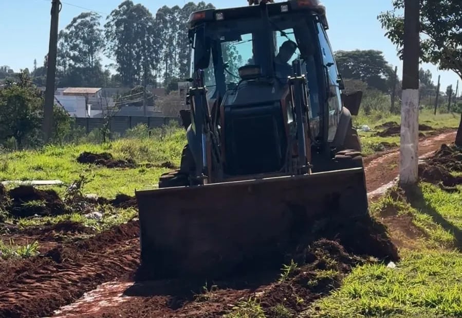 Retroescavadeira trabalhando em estrada rural