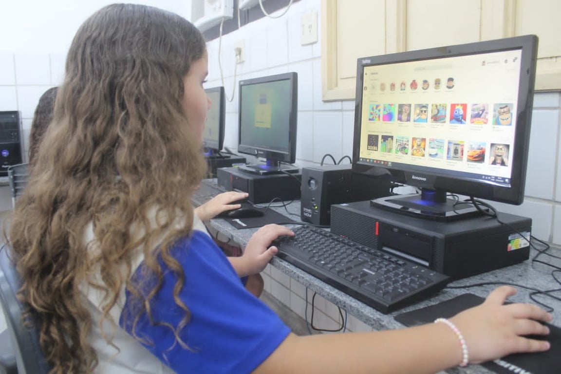 Laboratório de informática com estudante em atividade — ambiente universitário